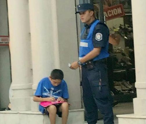 La historia detrás de la foto viral del policía ayudando a estudiar a un chico