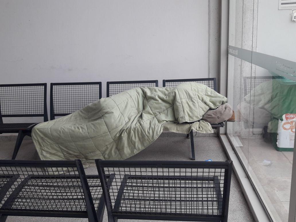 Una persona durmiendo en la terminal de ómnibus