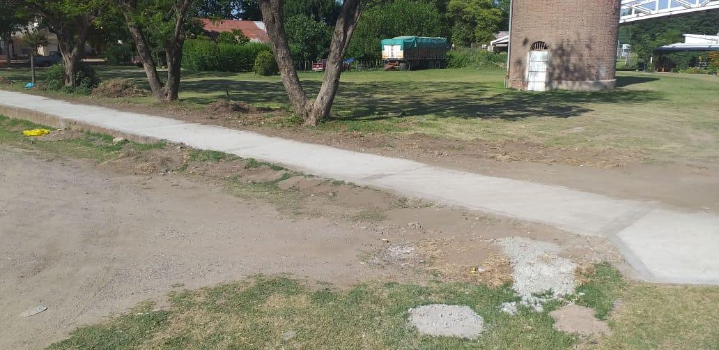 Veredas perimetrales del cuadro del ferrocarril,  una vivienda en el interior del predio y dos camiones que ingresan y salen del lugar